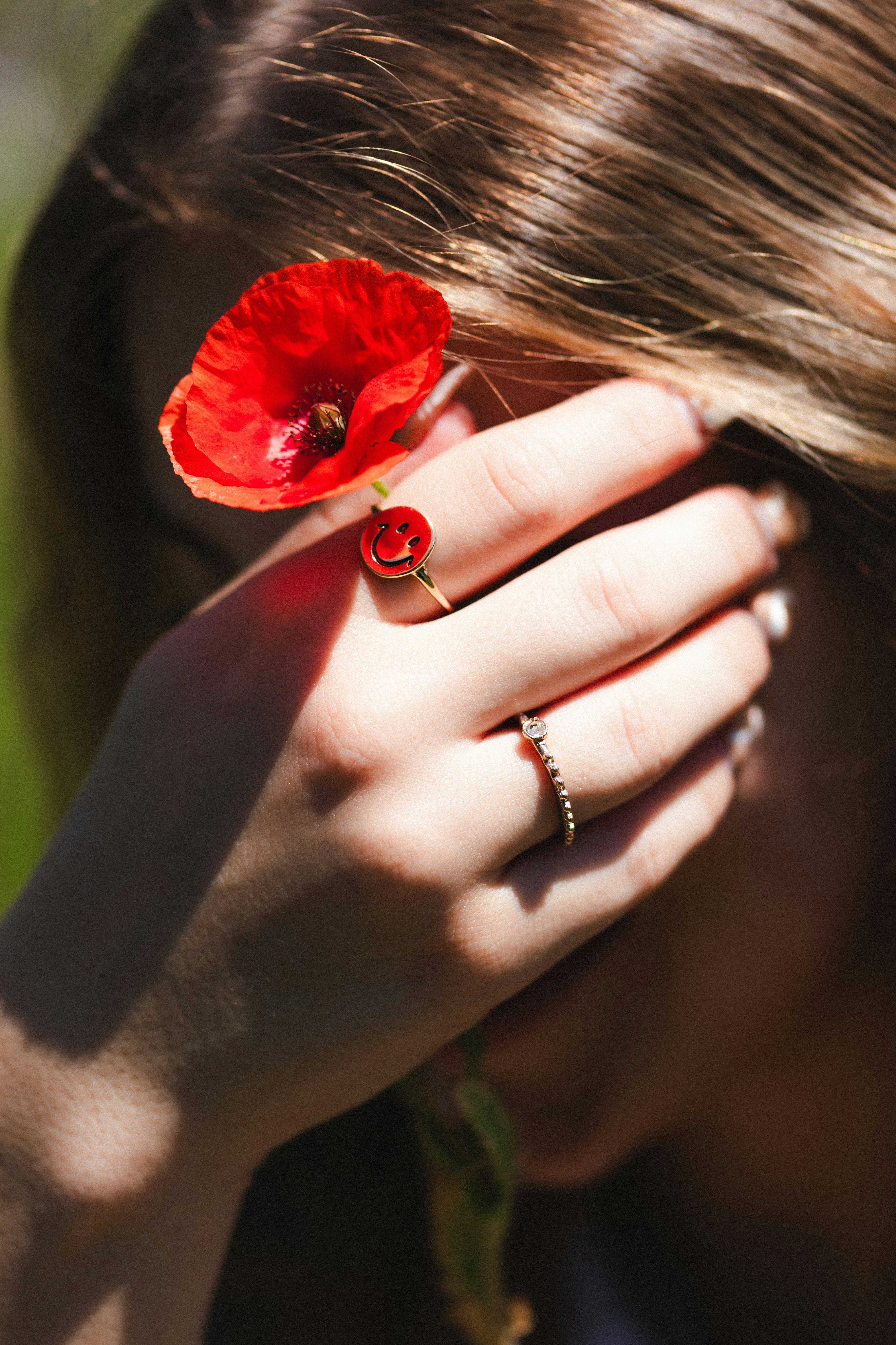 a woman holding a red flower in her hand