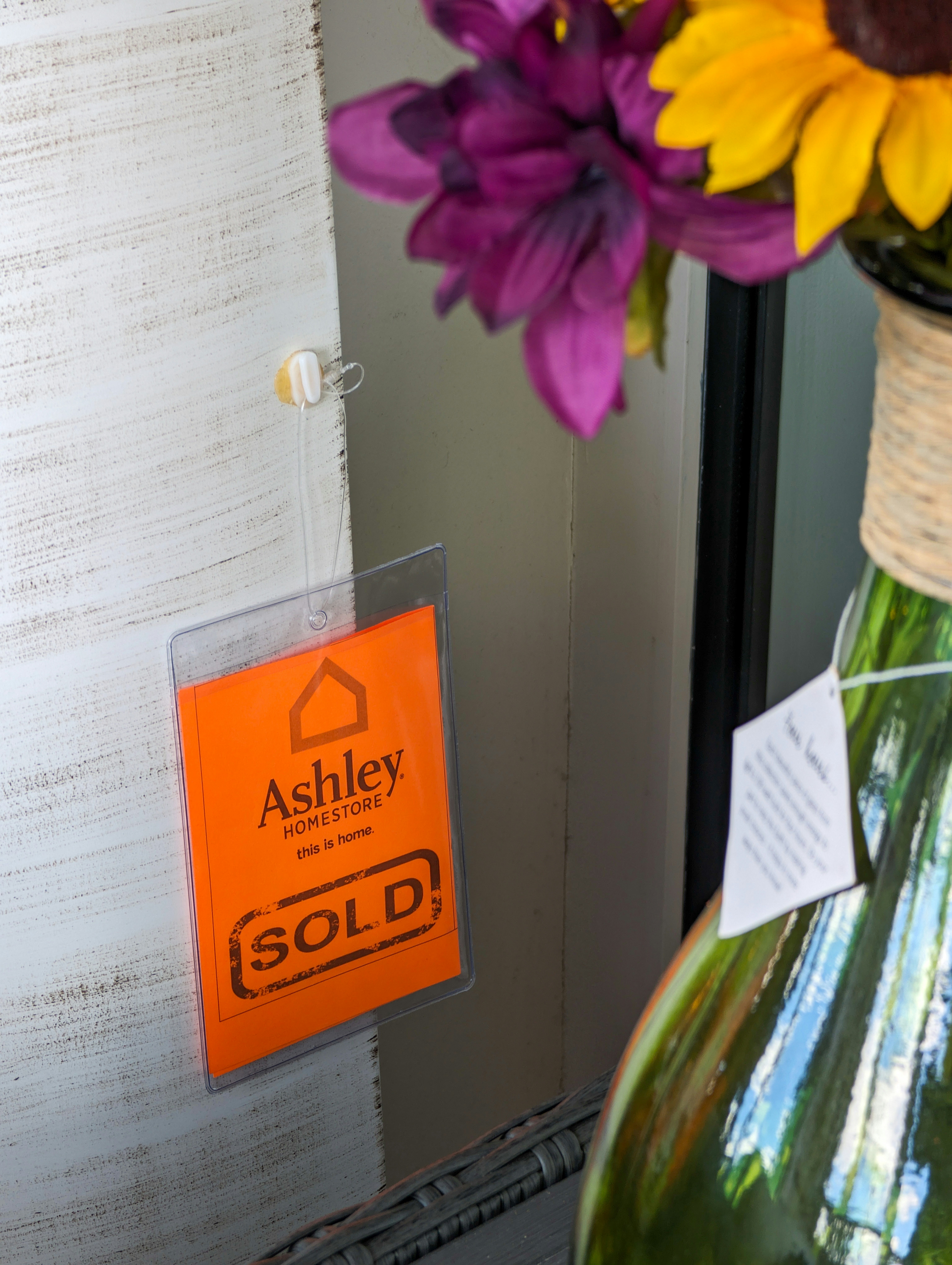 a vase with flowers and a sign on it