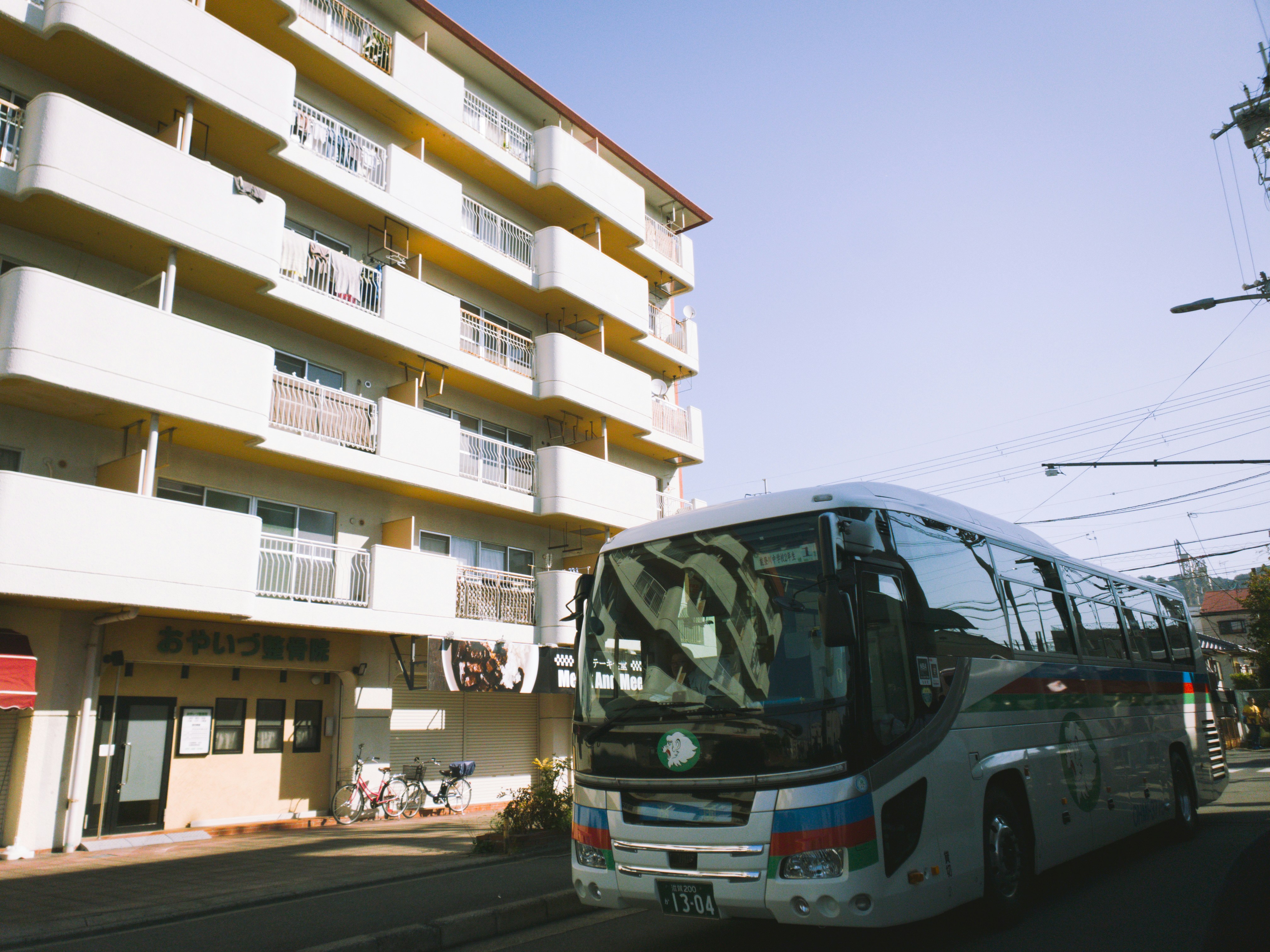 a bus driving down a street next to a tall building