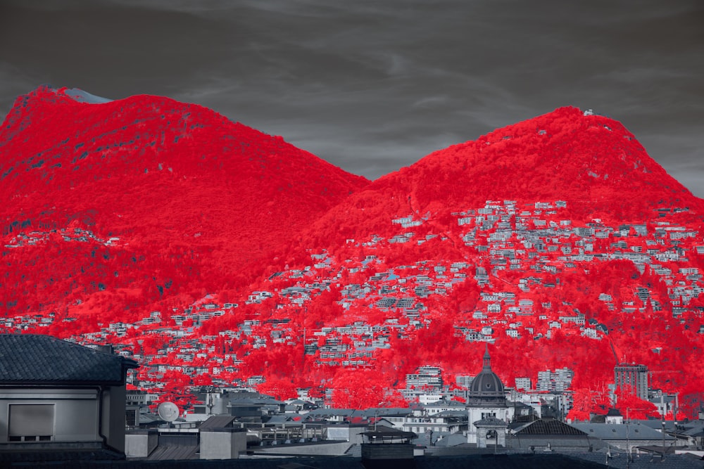a red mountain with a city below it