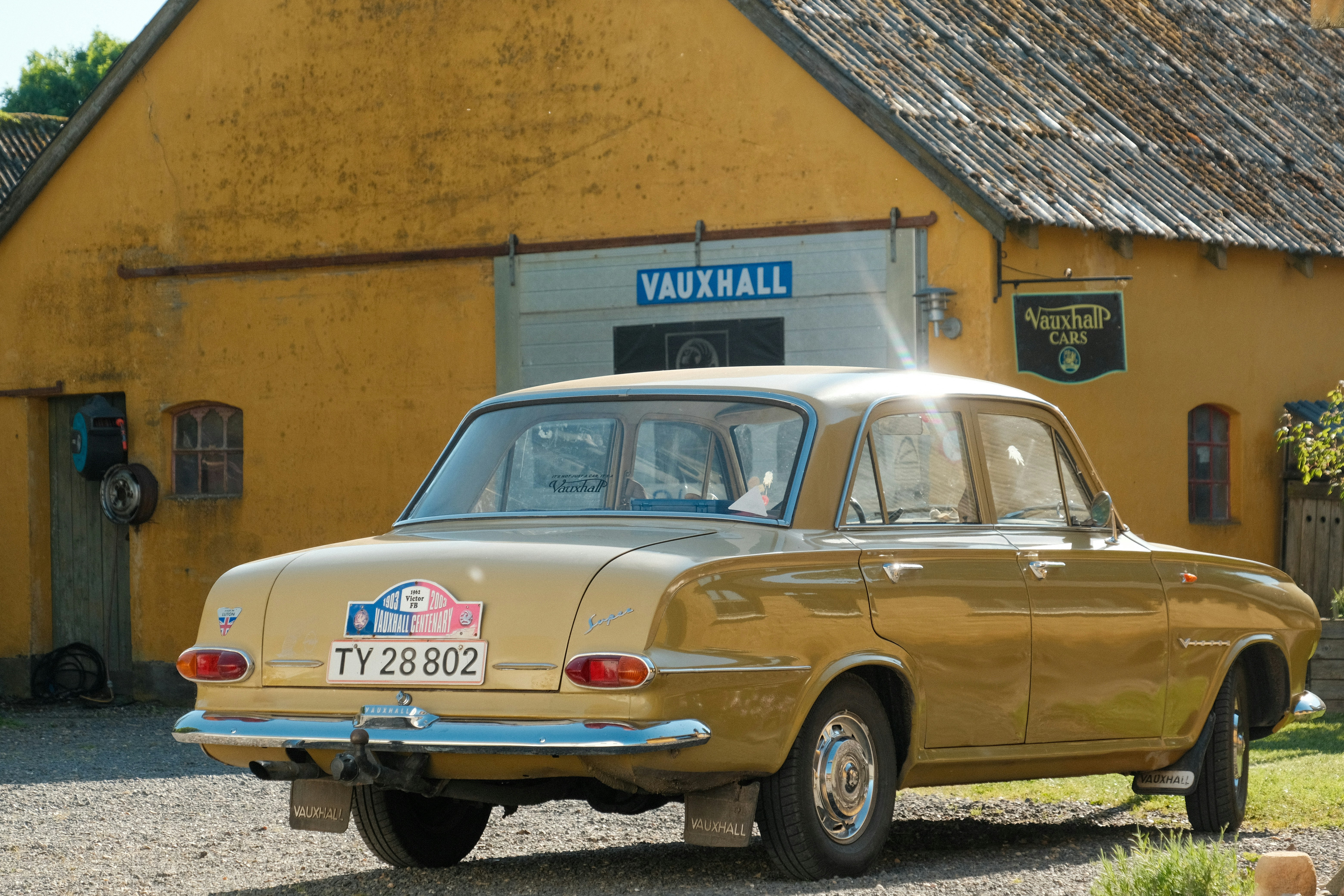 a car parked in front of a yellow building