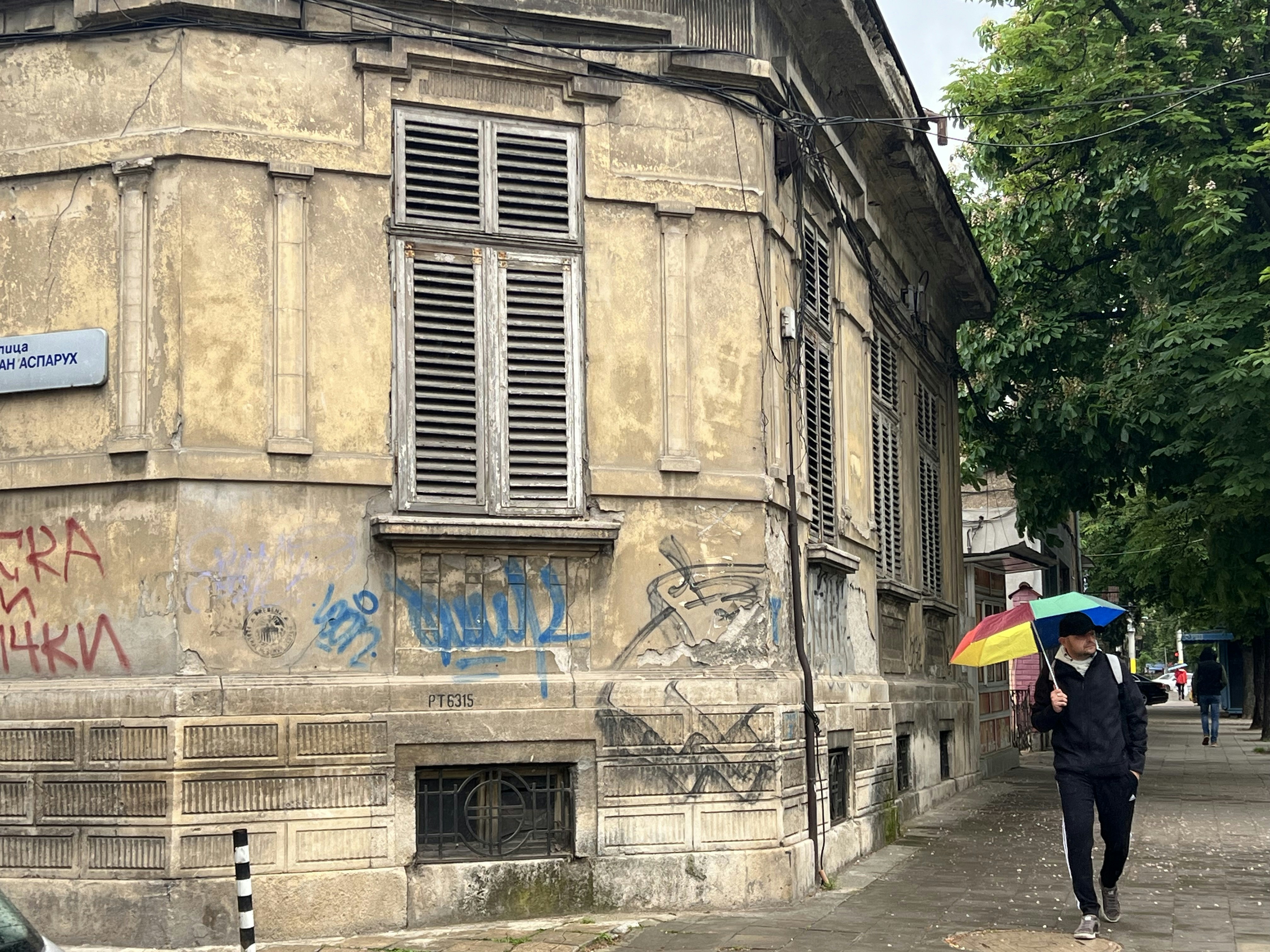 ein Mann, der mit einem Regenschirm in der Hand eine Straße entlang geht