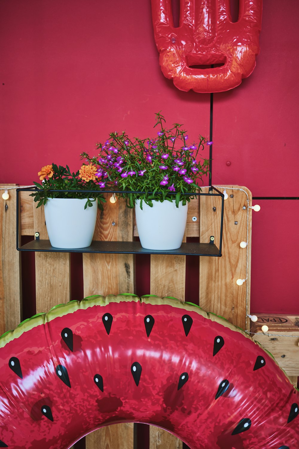 a planter filled with flowers sitting on top of a wooden shelf