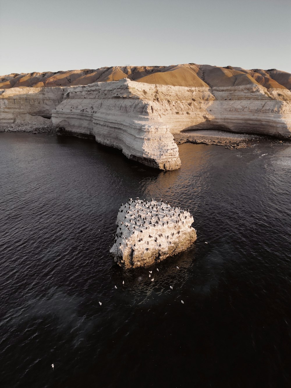 a body of water with a rock formation in the middle of it