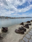 a row of shoes sitting on the shore of a lake