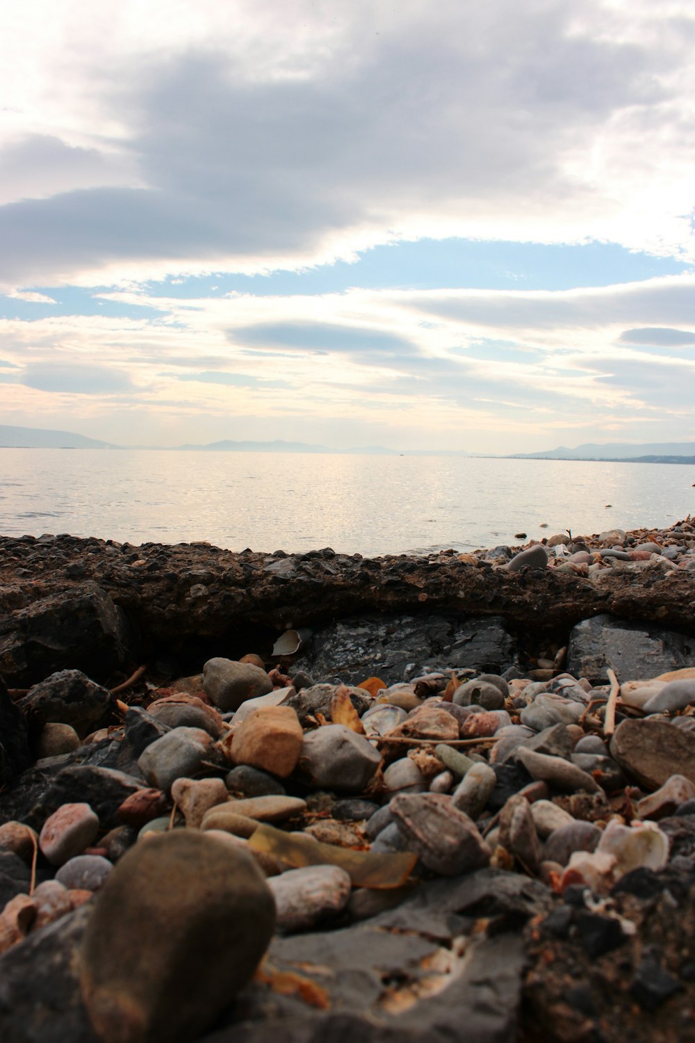 rocks and gravel on the shore of a body of water