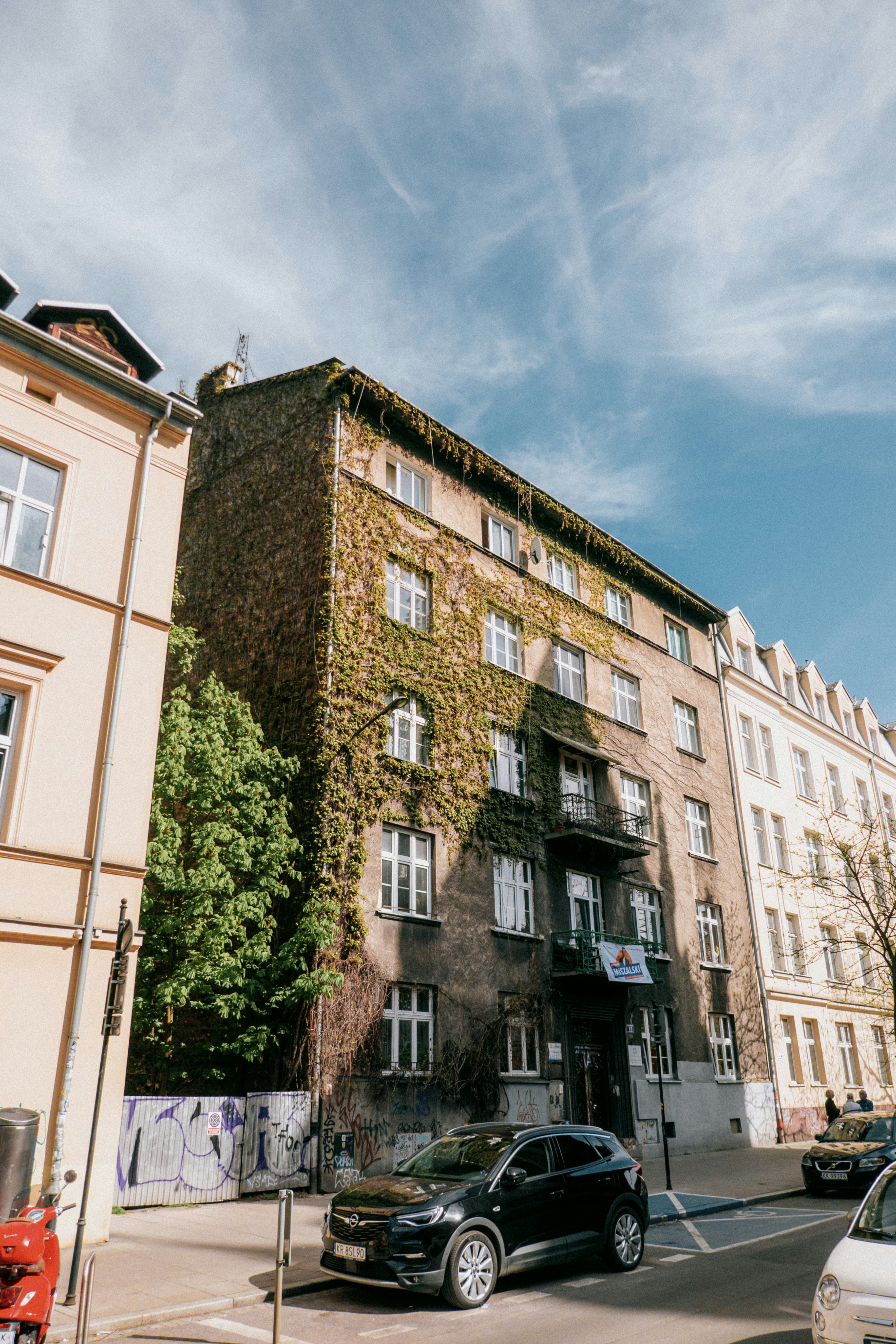 a black car driving down a street next to tall buildings