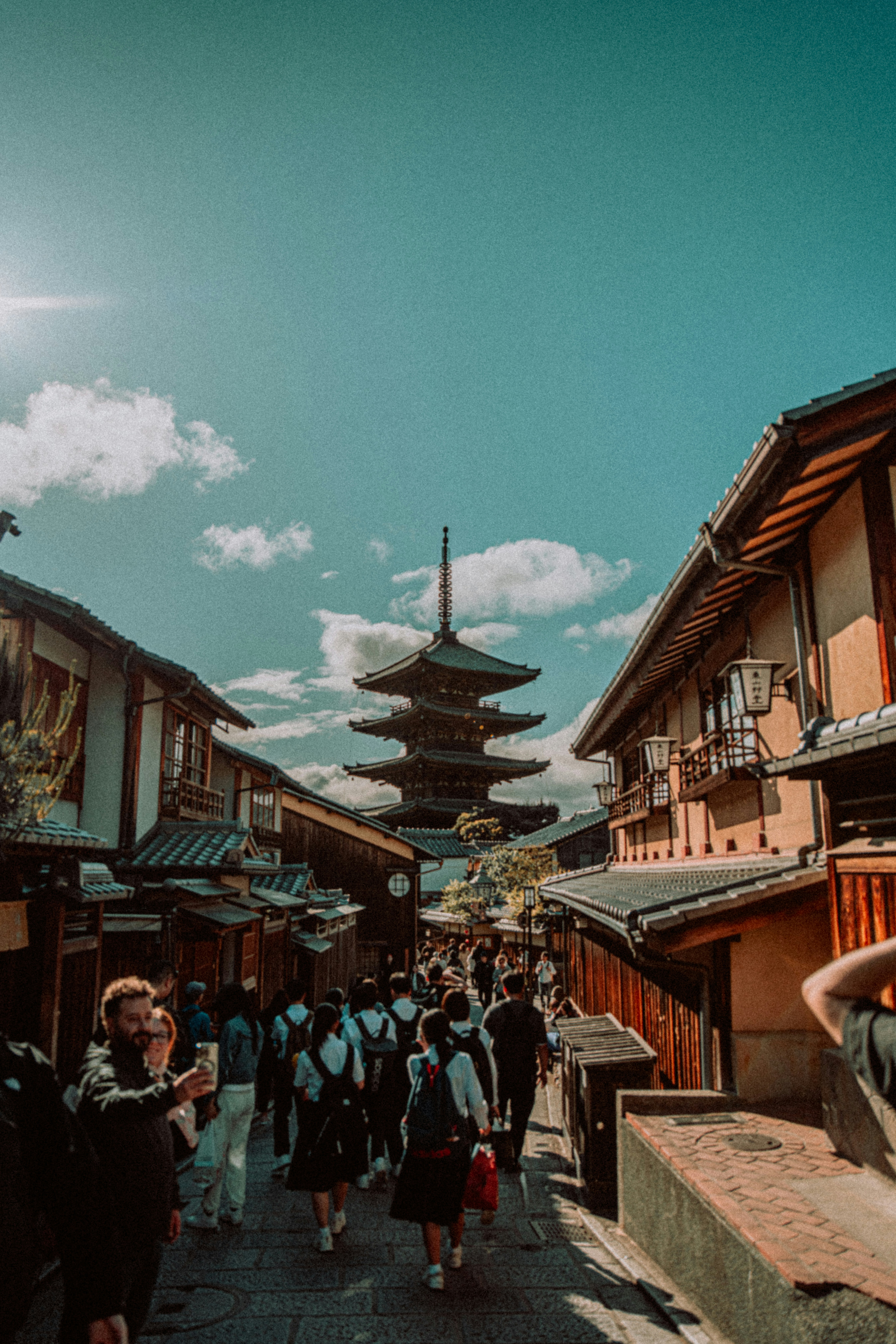 um grupo de pessoas andando por uma rua ao lado de edifícios altos