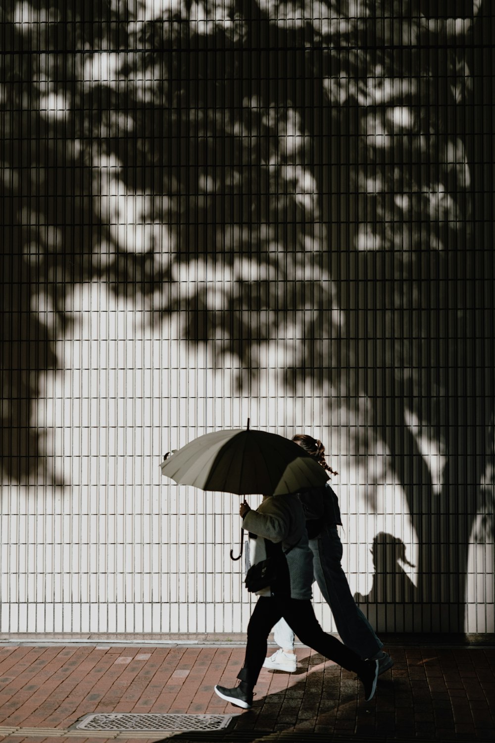 a person walking down a sidewalk with an umbrella