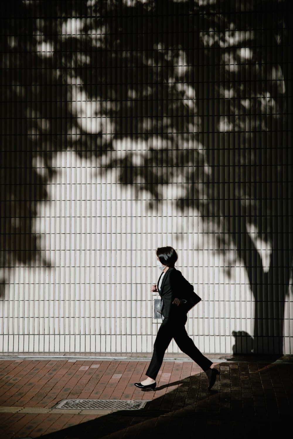 a man in a suit and helmet walking down a sidewalk