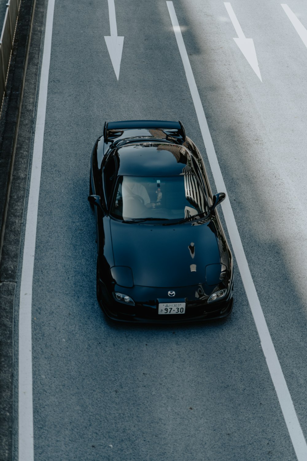 a black sports car driving down a street