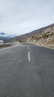 a person riding a motorcycle down the middle of a road