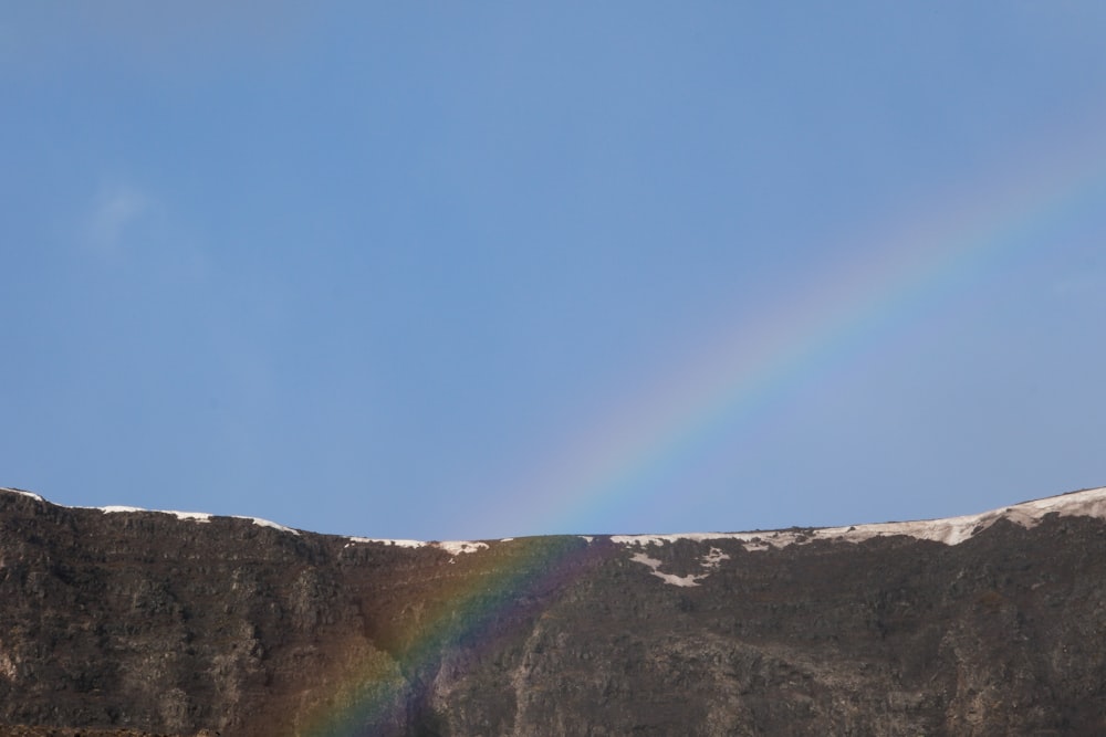 a rainbow in the sky over a mountain