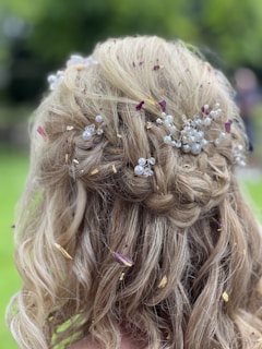 a close up of a woman's hair with flowers in it