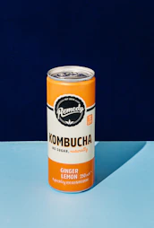 a can of kombucha on a blue surface