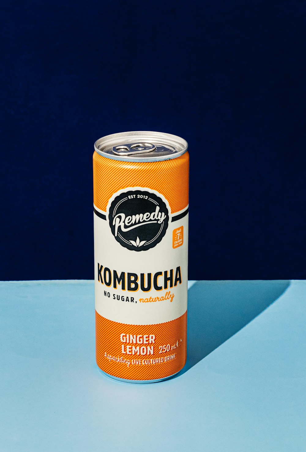 a can of kombucha on a blue surface