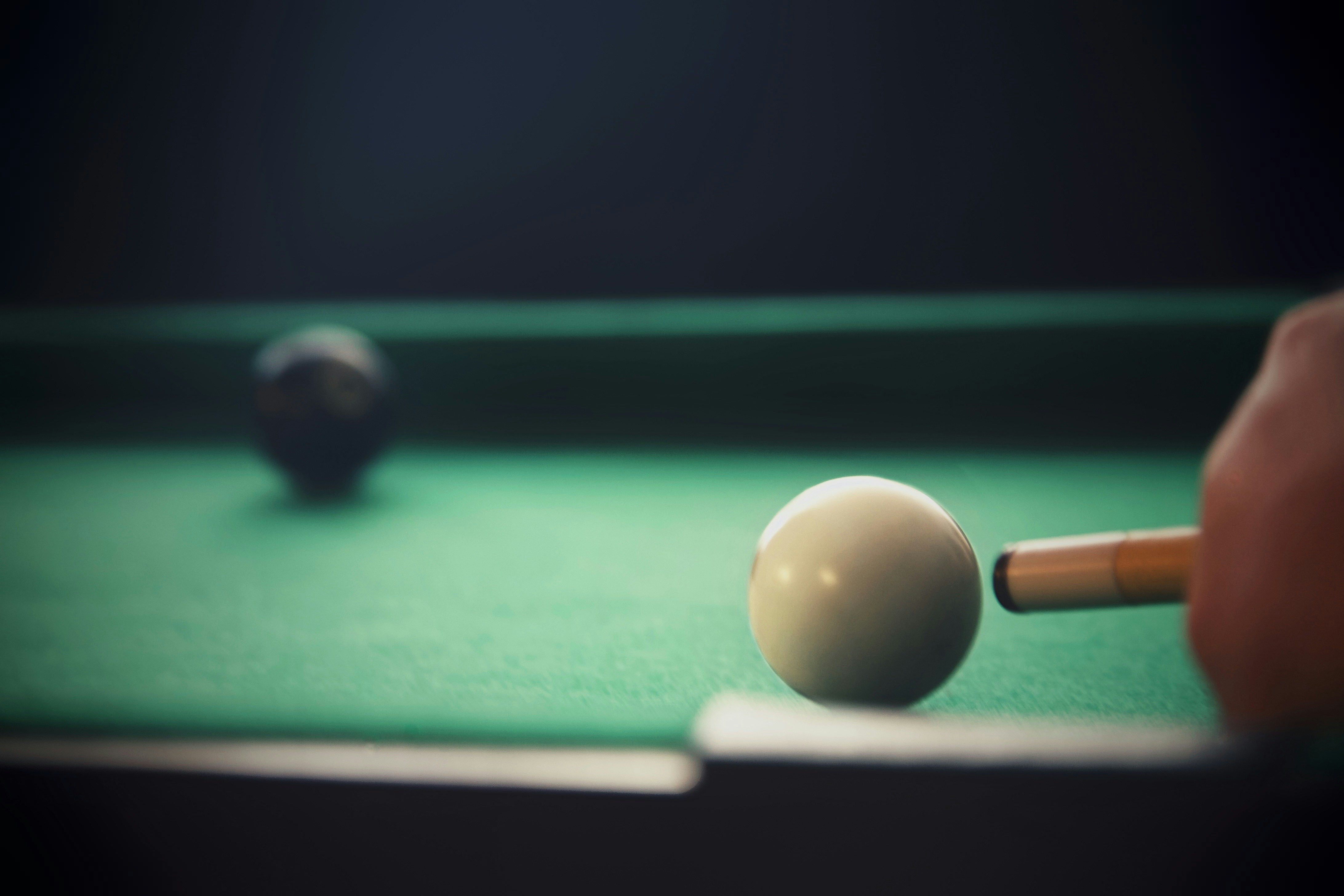 a pool table with a pool ball and a cue