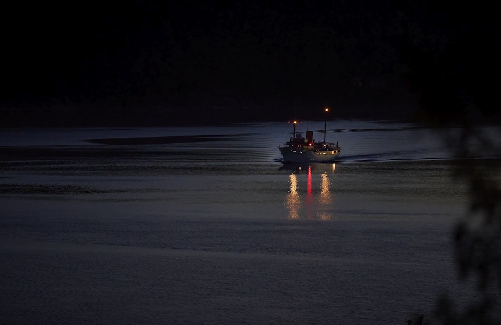 a boat is out on the water at night