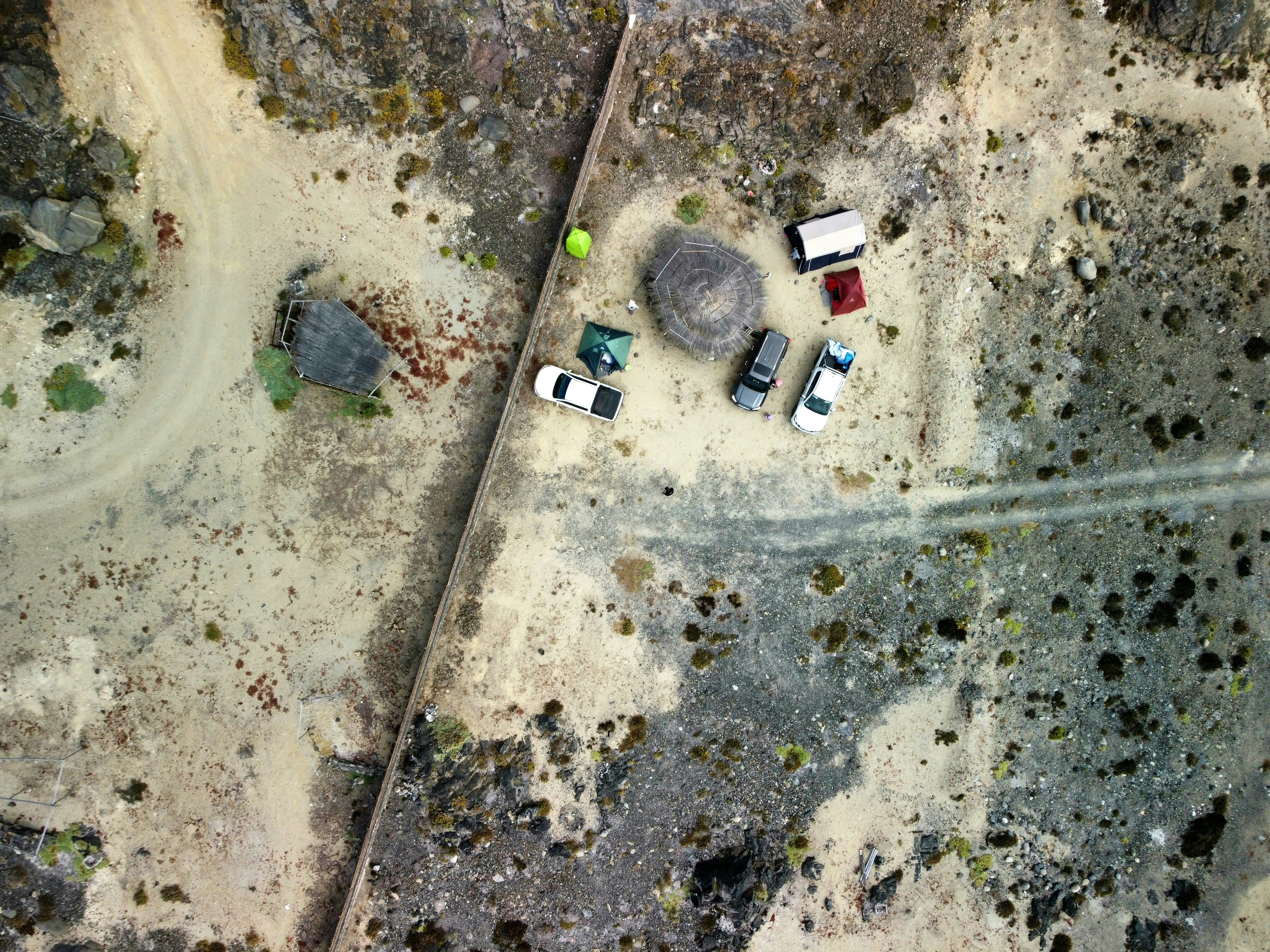 a group of cars parked on top of a dirt field