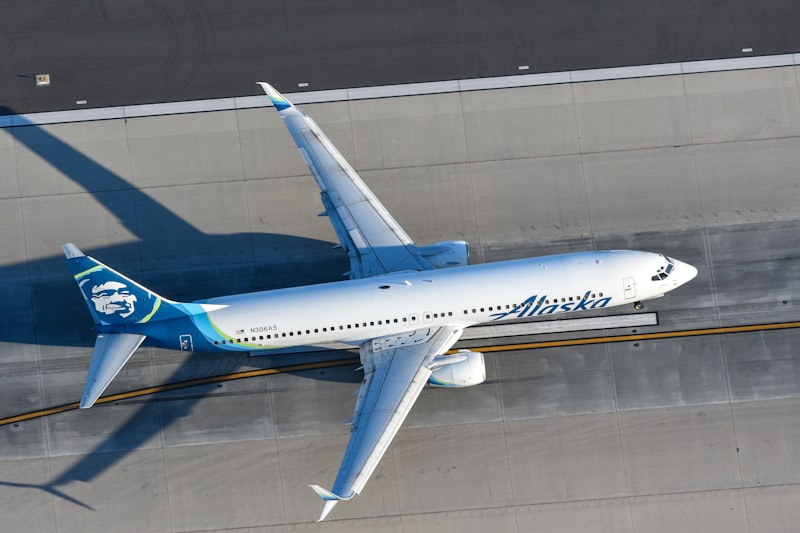 a white and blue airplane flying over a runway
