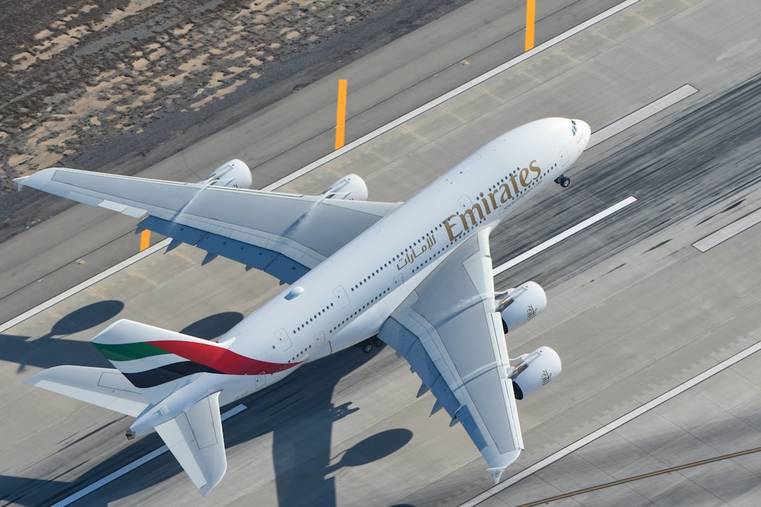 a large passenger jet sitting on top of an airport tarmac, Emirates A380 Departing Los Angeles