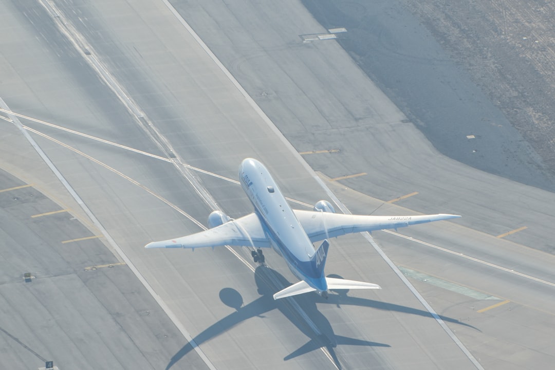 a large jetliner flying over an airport runway, All Nippon Airways (ANA) 787 Departing Los Angeles