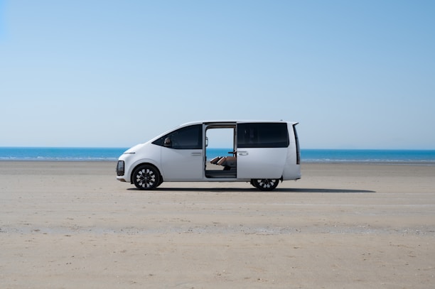 a white van parked on top of a sandy beach