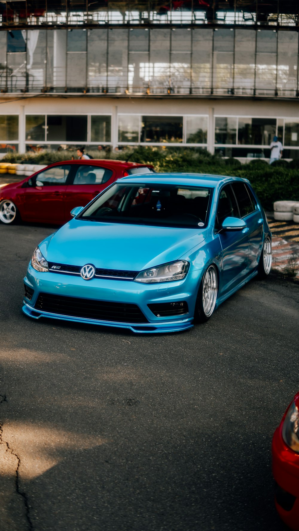a blue vw golf is parked in a parking lot