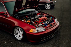 a red car with its hood open and the hood up