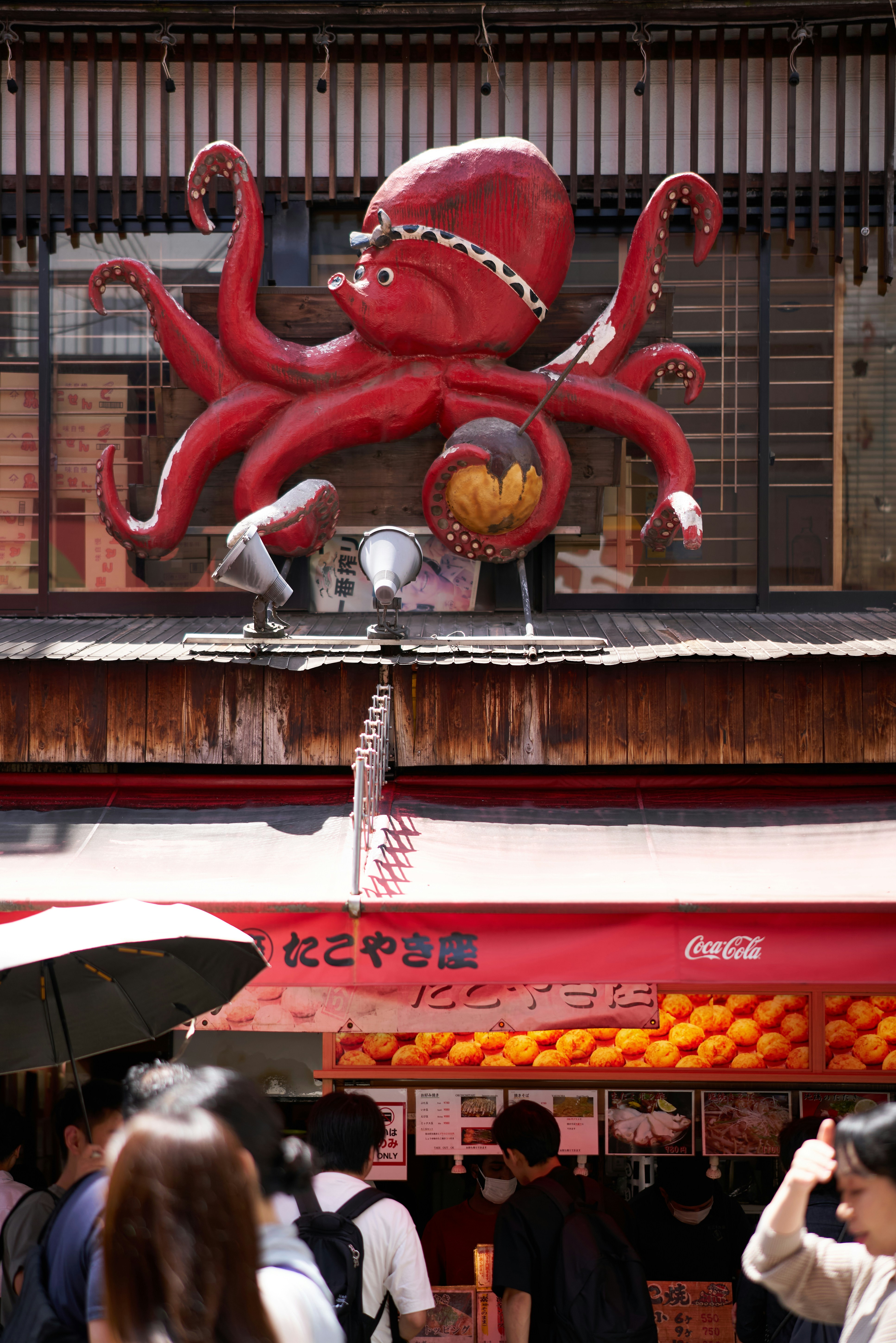 a large red octopus sculpture on the side of a building