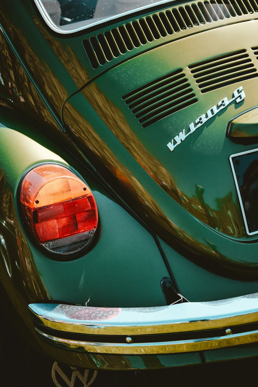 a close up of the tail lights of a green vw bug