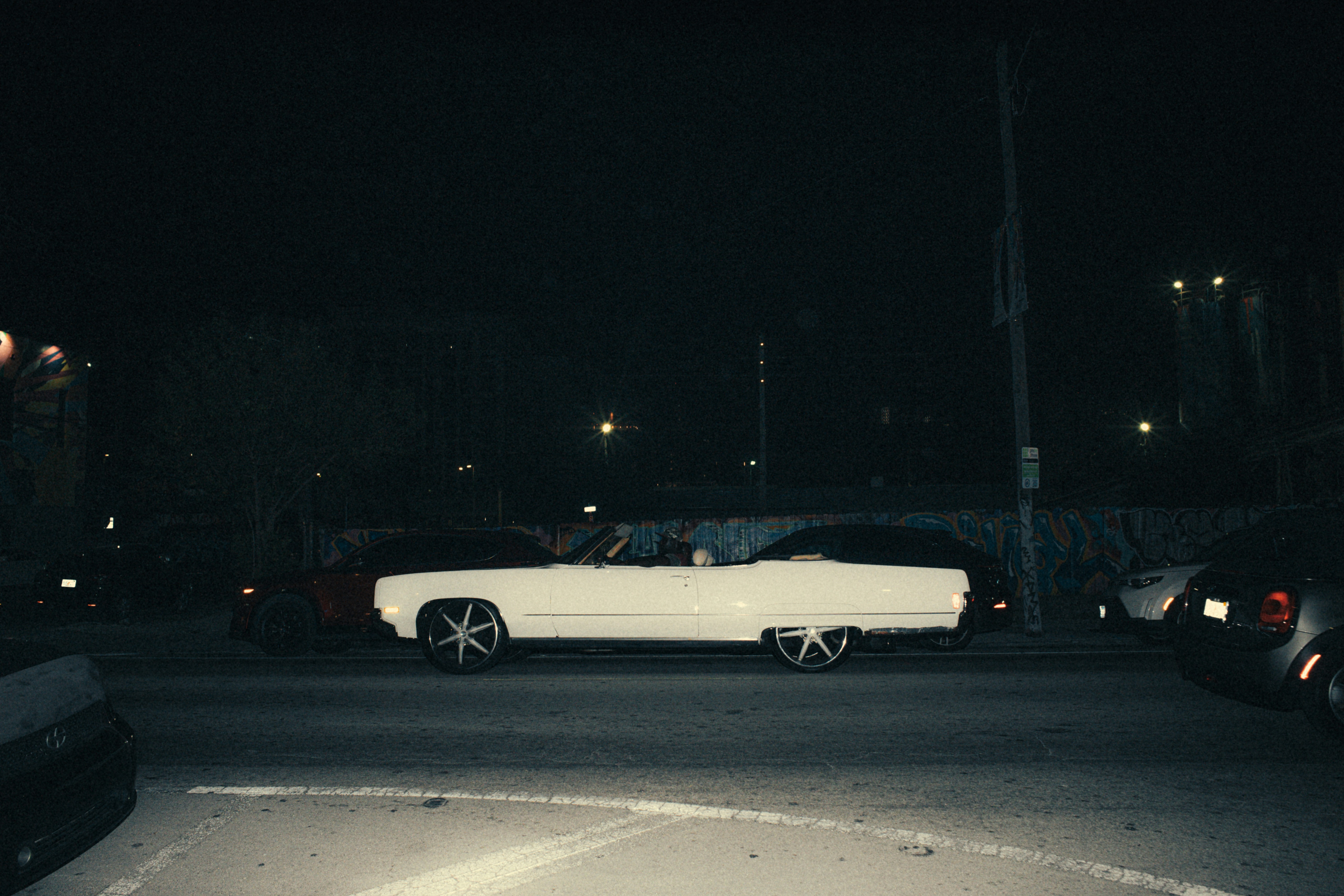 a white car parked in a parking lot at night