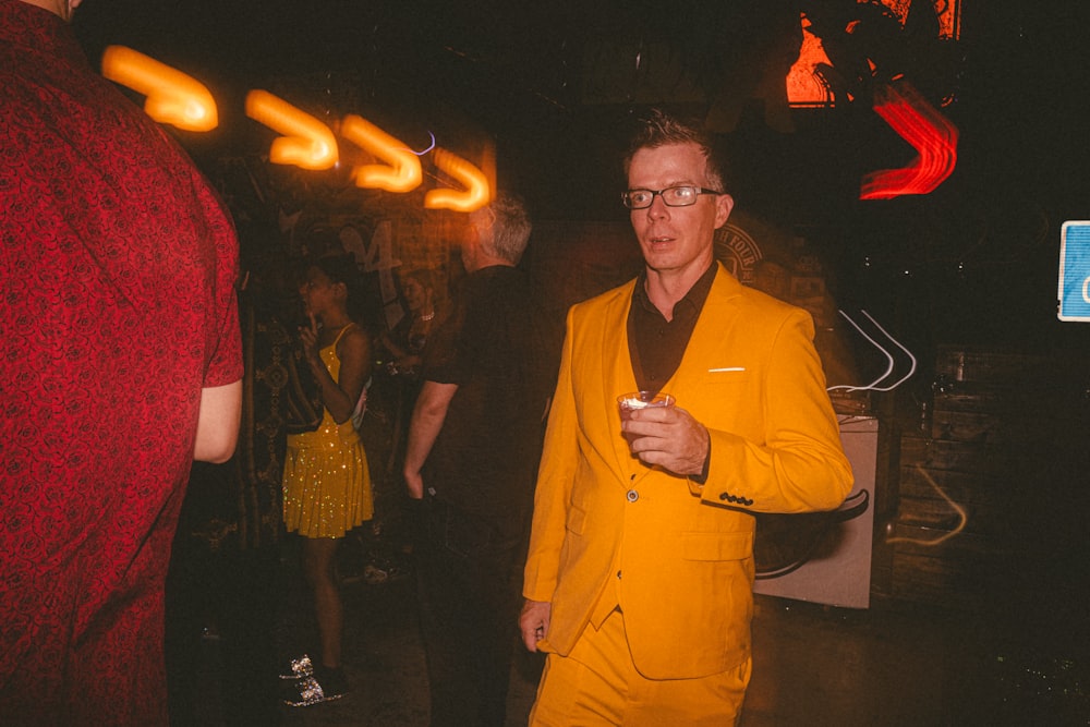 a man in a yellow suit standing next to a woman