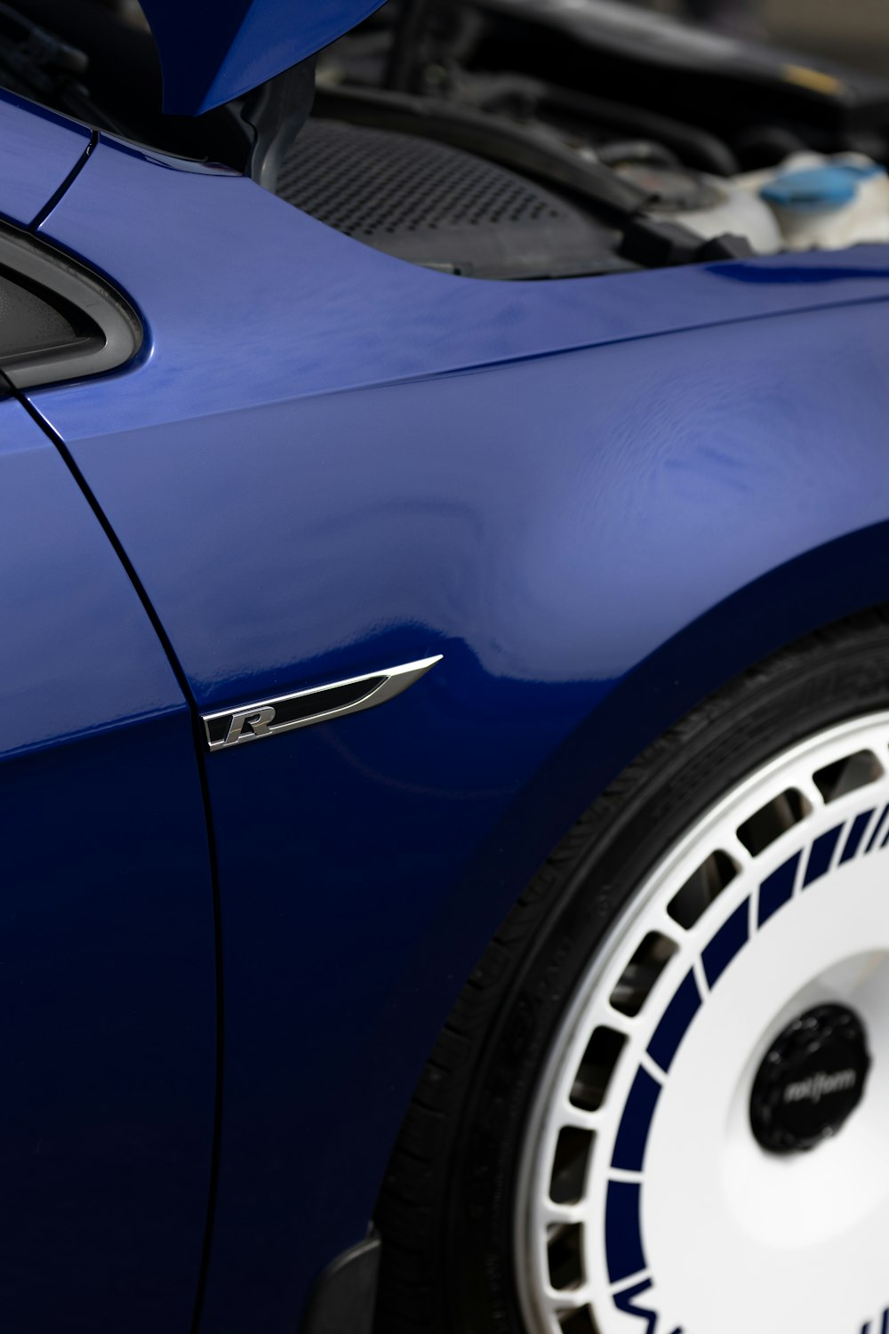 a close up of the hood of a blue sports car