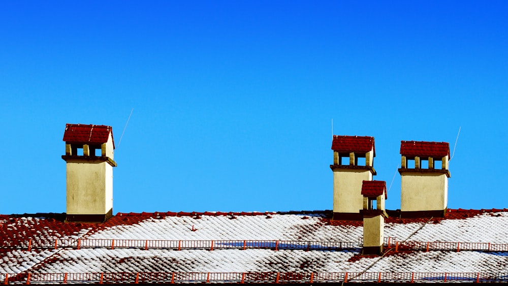 three chimneys on top of a roof covered in snow