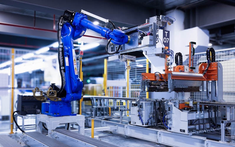 Blue industrial robot arm assembling parts on automated factory line with 3D machine vision software