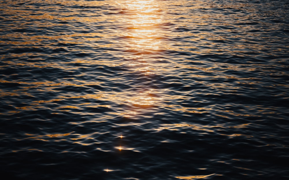 a large body of water with the sun reflecting off of the water