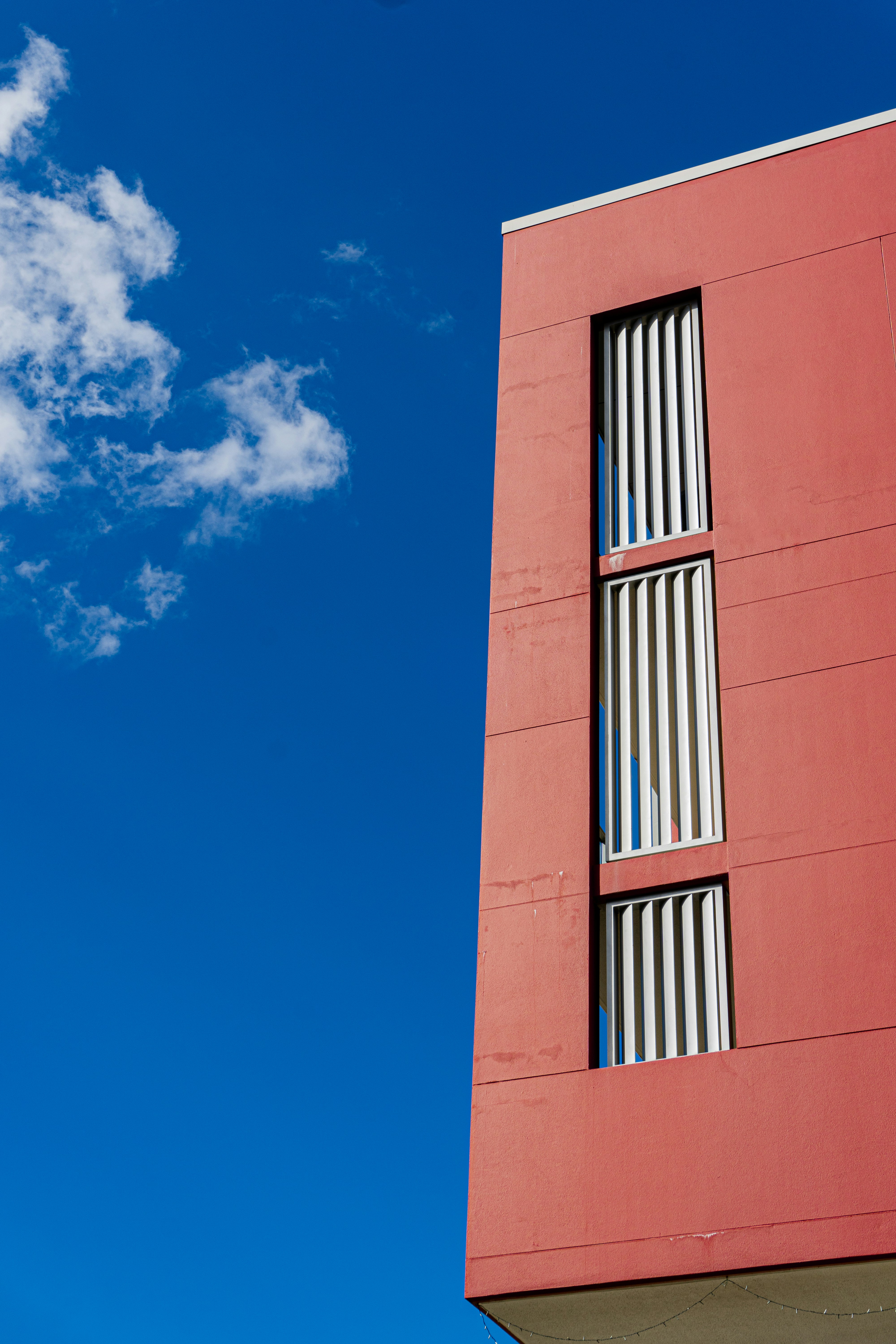 a tall red building with a sky background