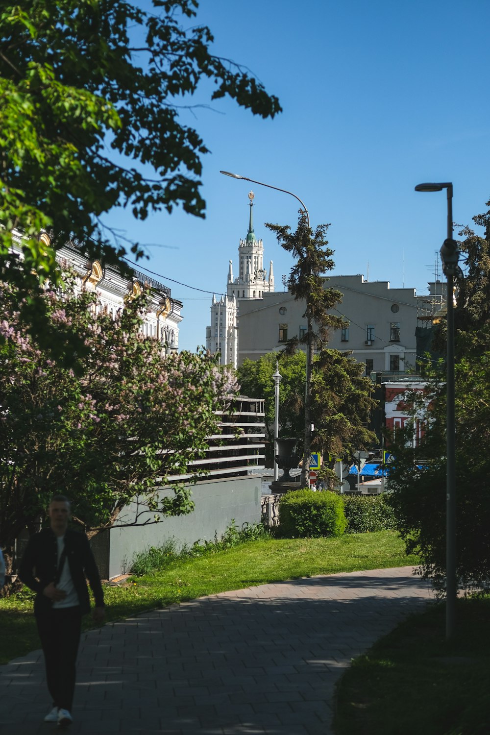 a woman walking down a sidewalk in a city