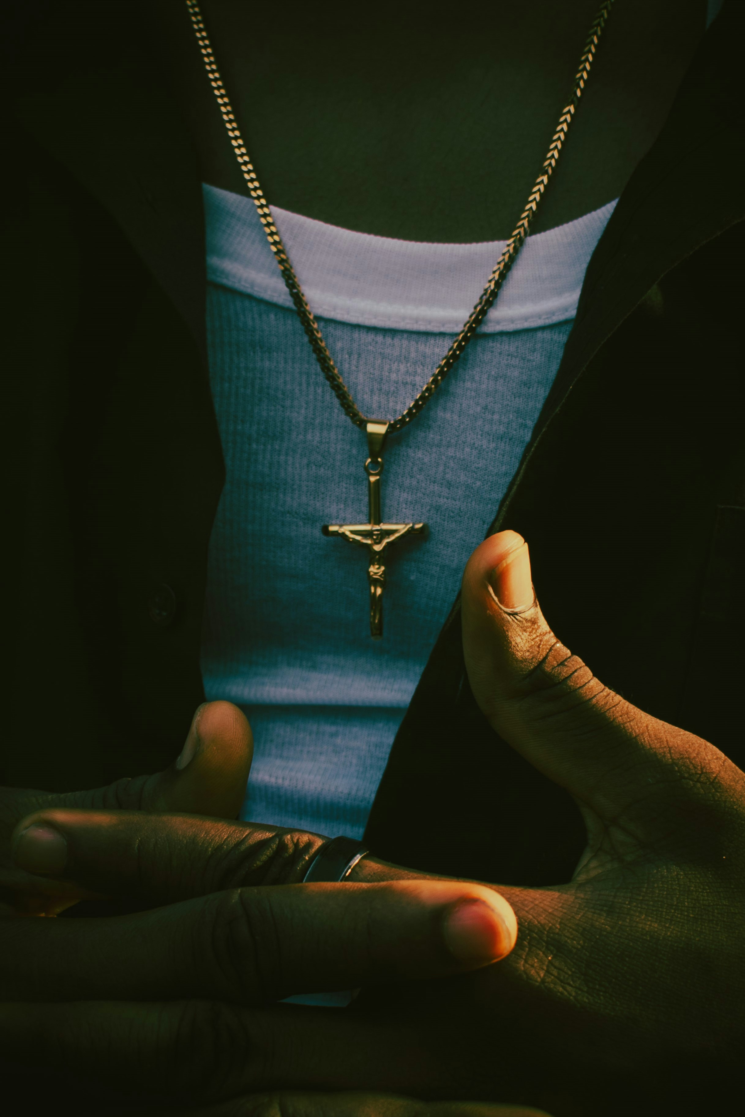 a person wearing a necklace with a cross on it