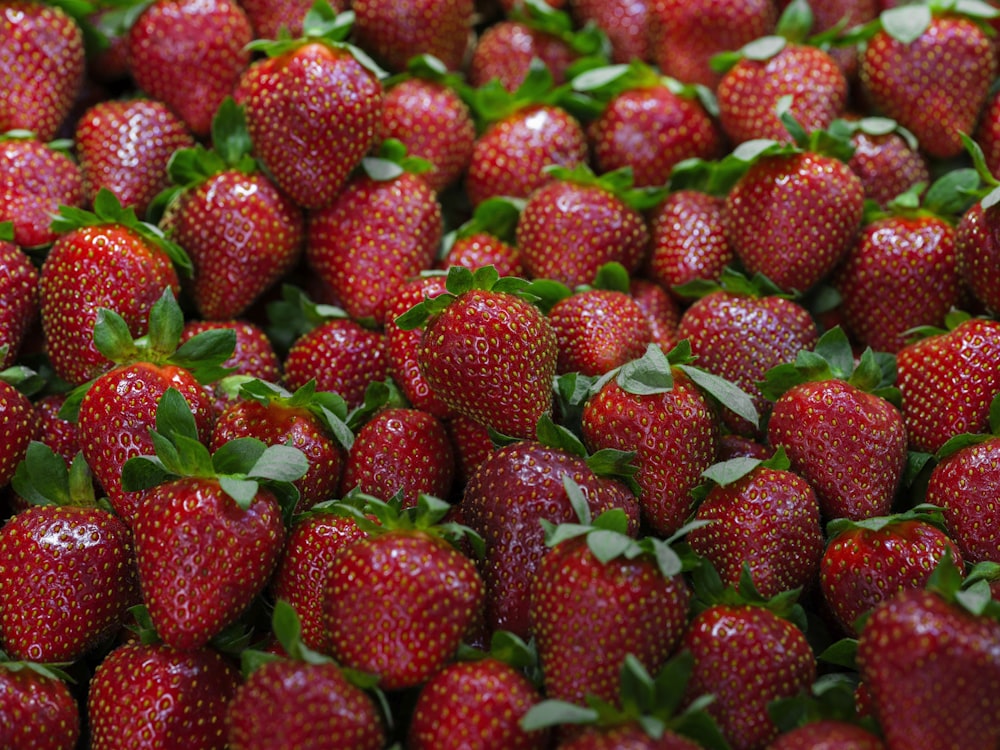 a large group of strawberries with leaves on them