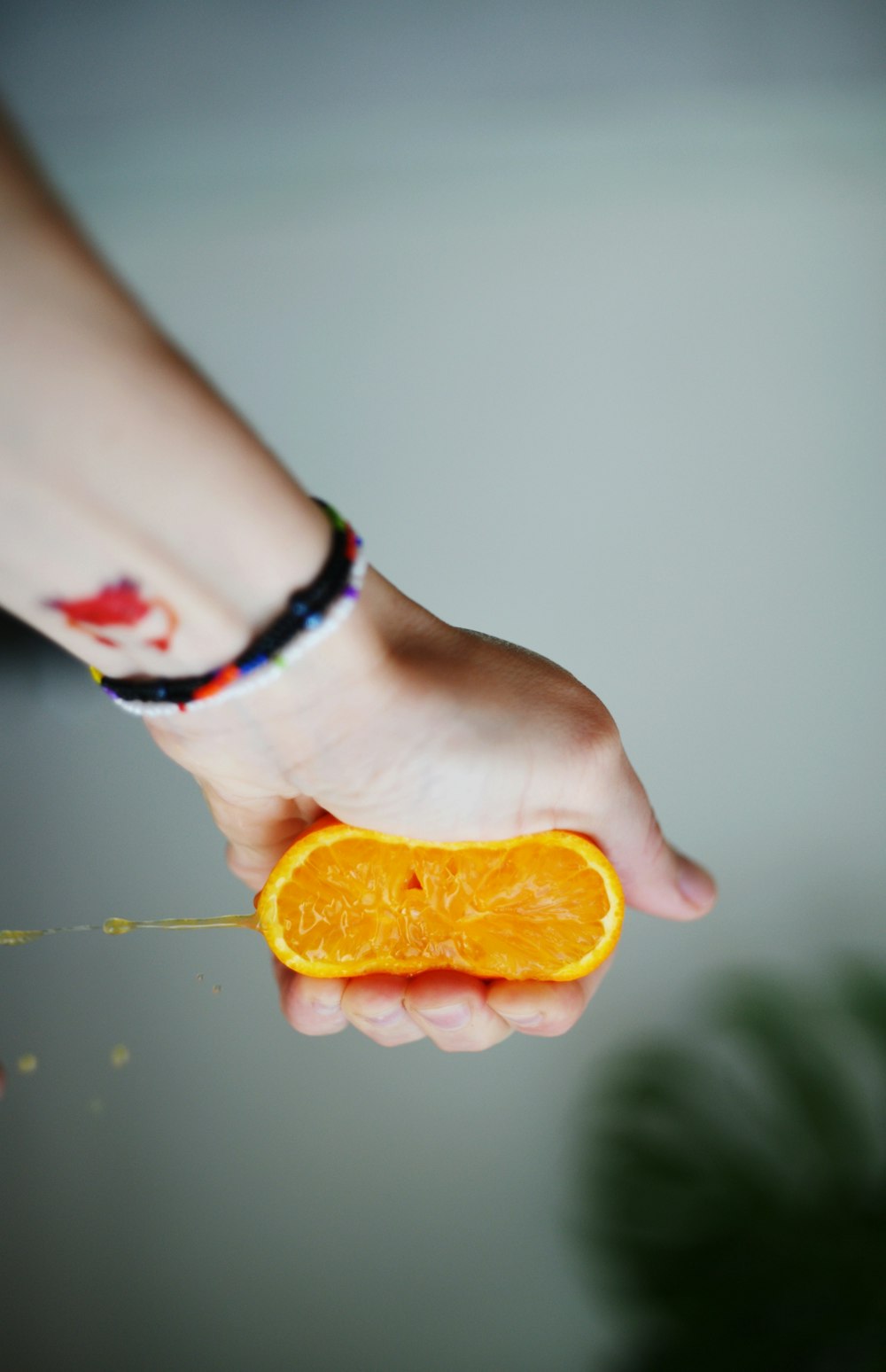 a person holding an orange slice in their hand