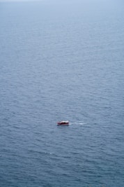 a small boat floating on top of a large body of water