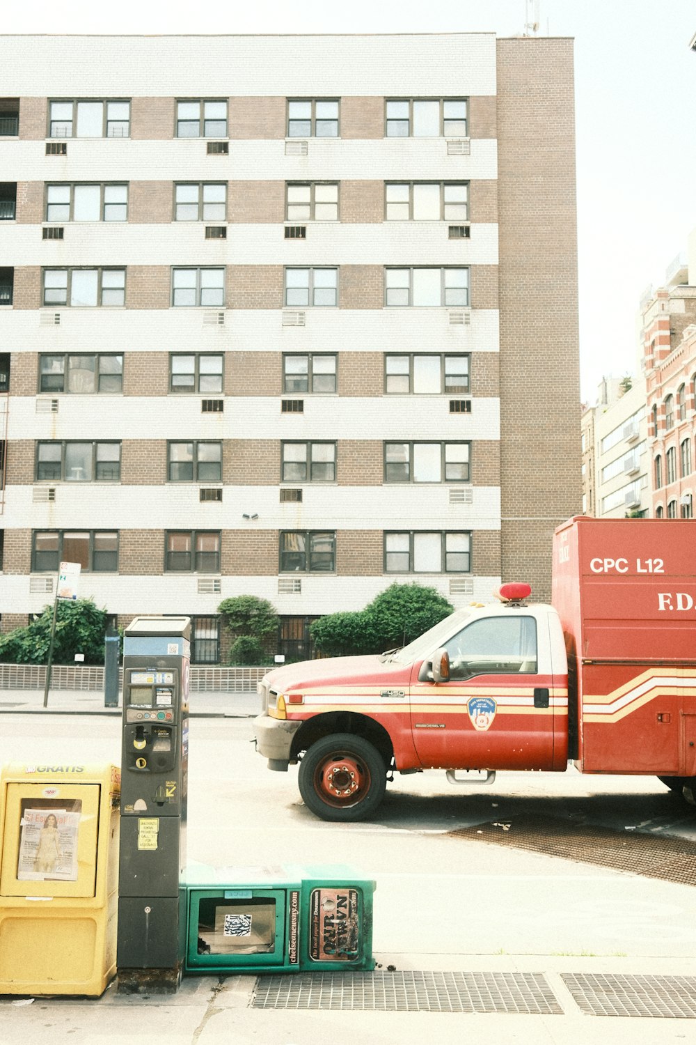a red truck parked in front of a tall building