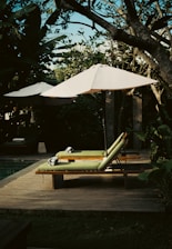 a lounge chair with an umbrella on a deck