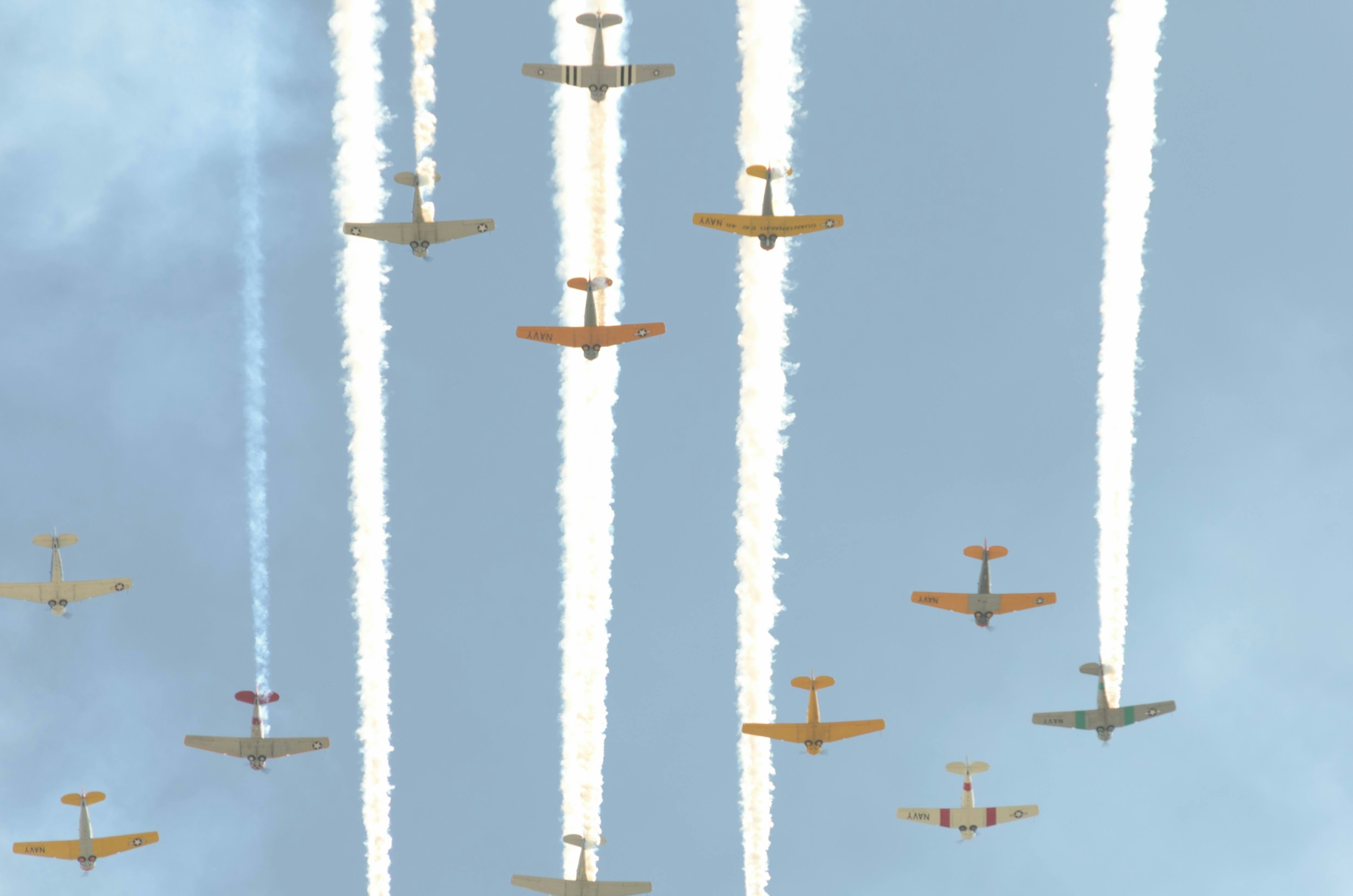 a group of airplanes flying through a blue sky