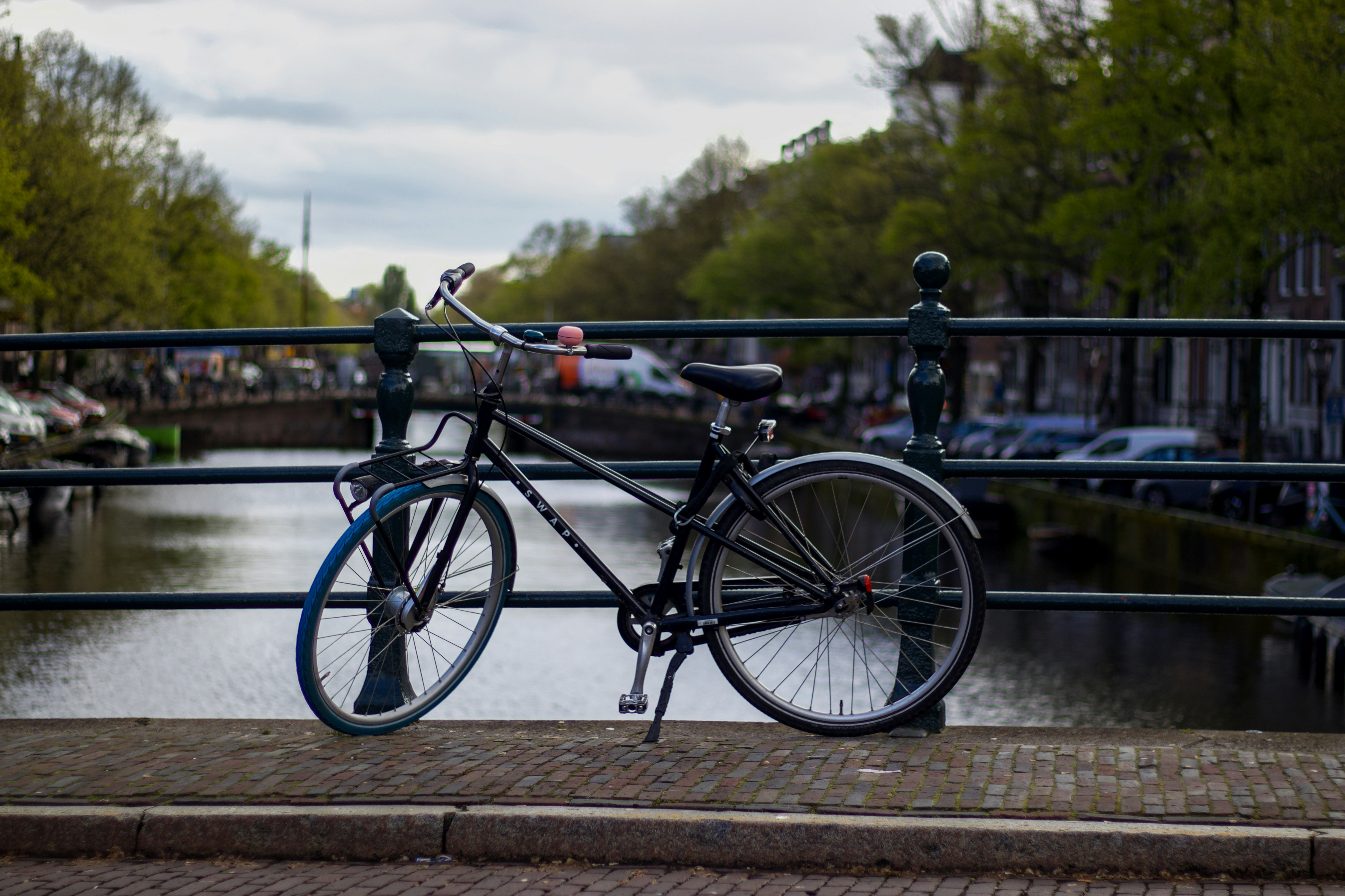 a bicycle parked on a bridge over a river