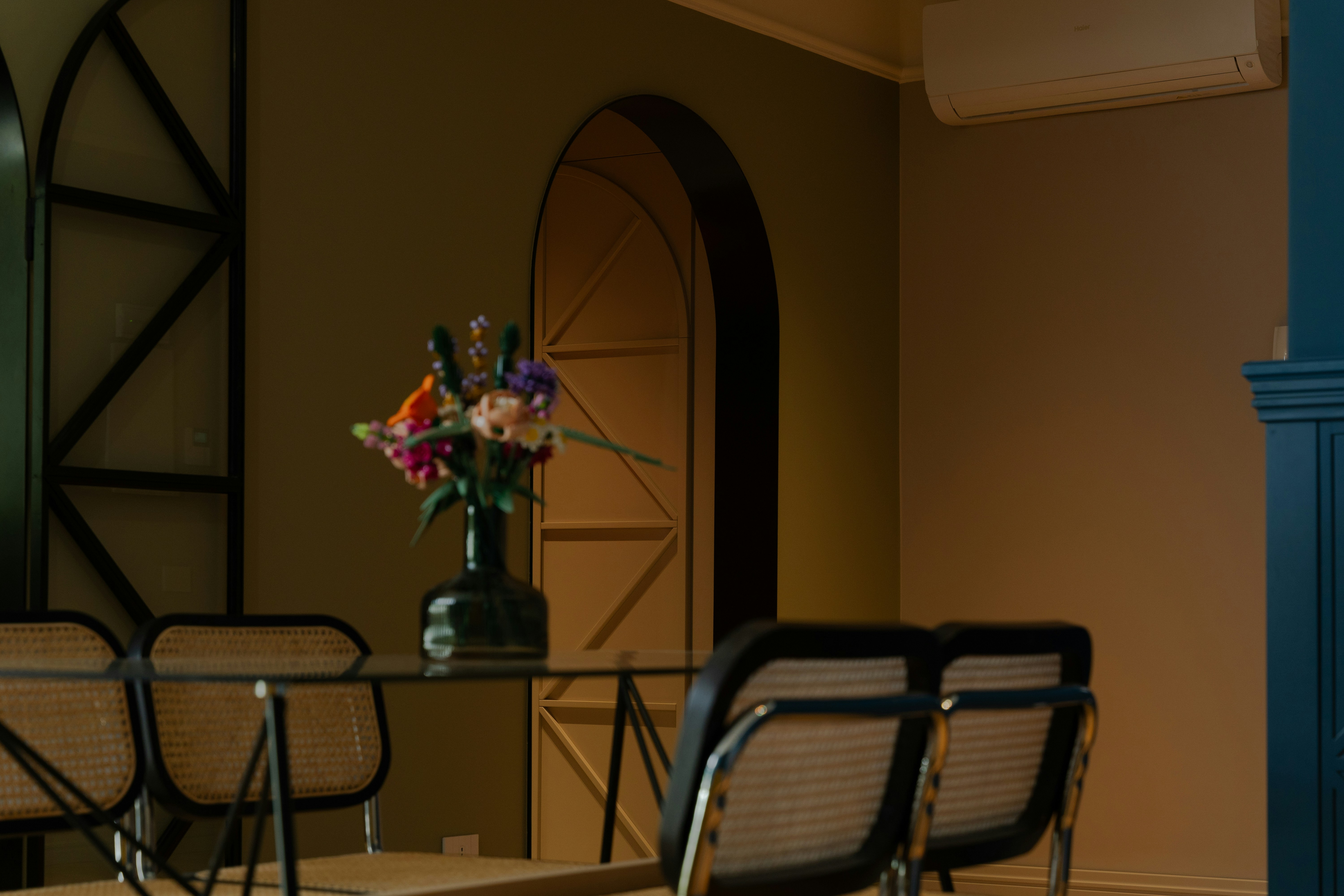 a table with chairs and a vase with flowers on it