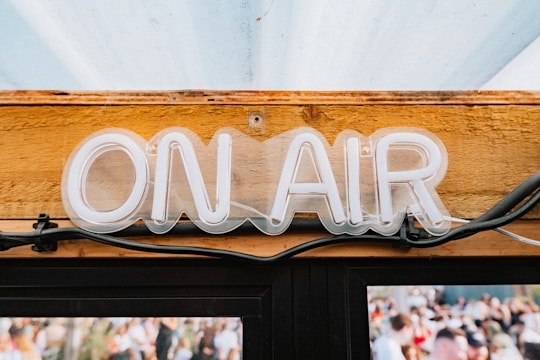 a neon sign that reads on air above a door