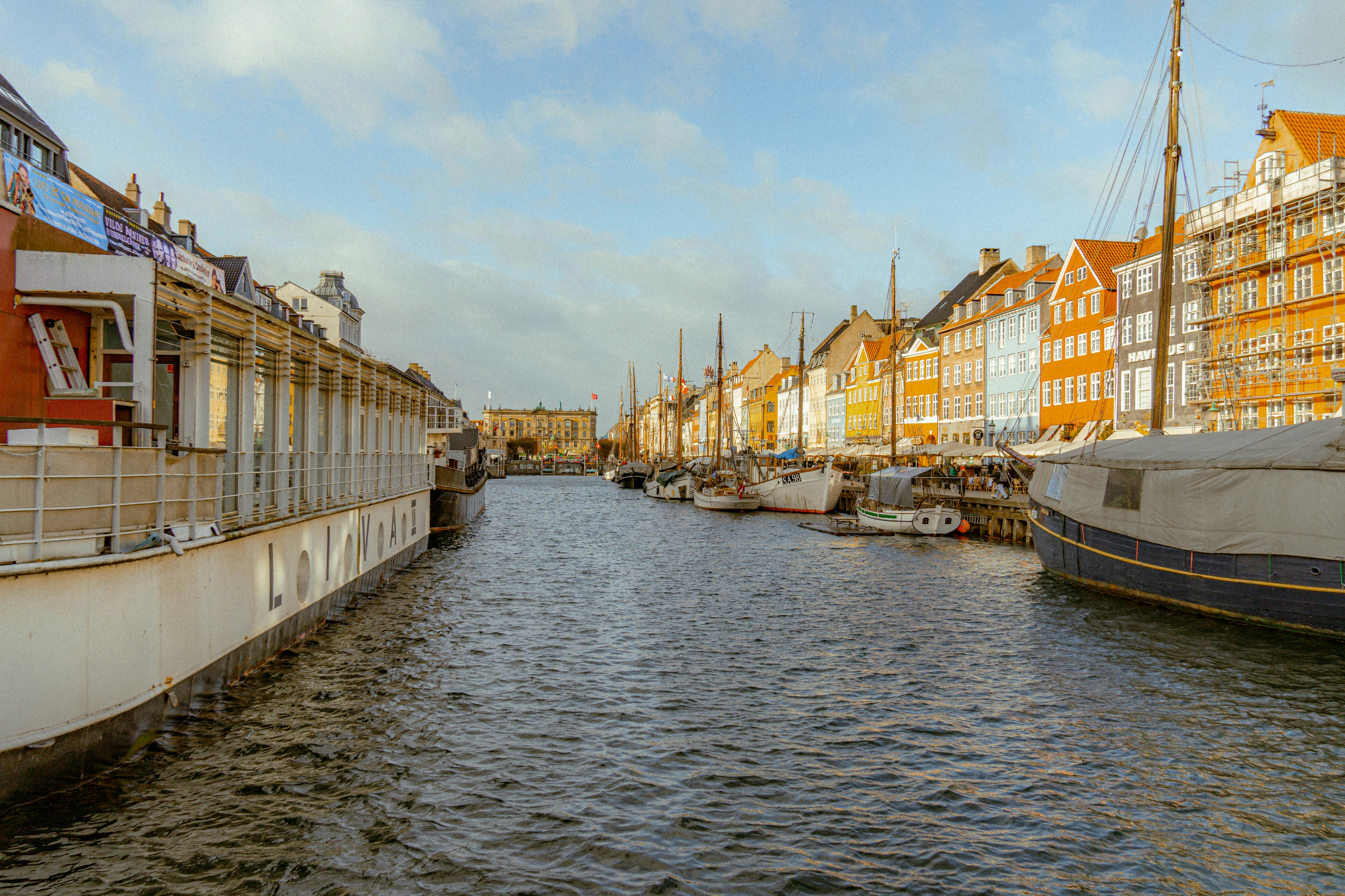 a body of water next to a row of buildings, 